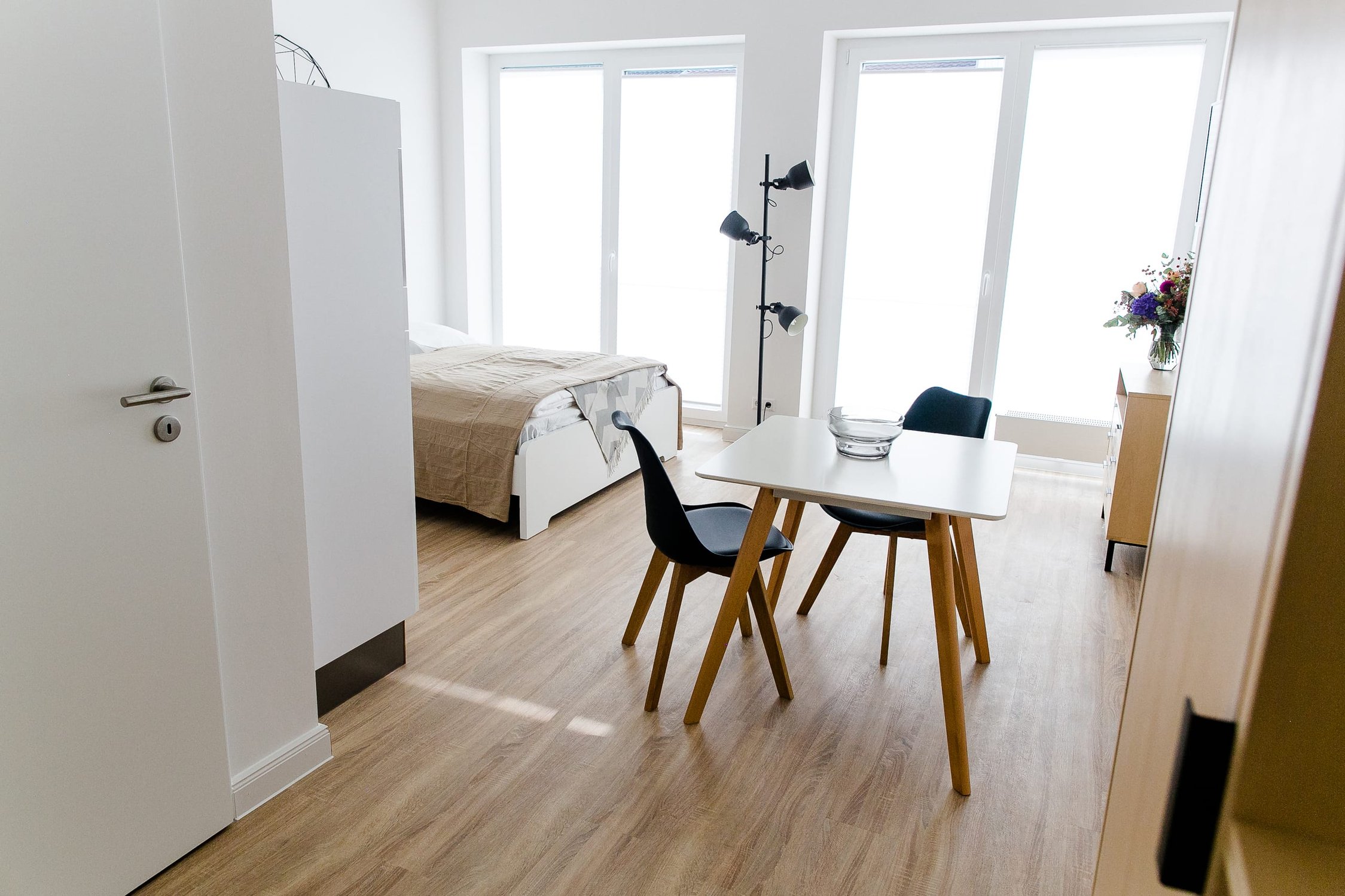 Helles Studio-Apartment mit Bett, Esstisch für zwei Personen und großflächigen Fenstern